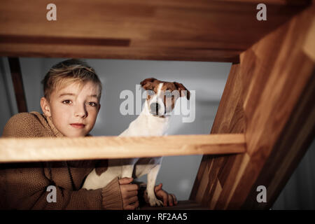 Portrait of boy with Jack Russel terrier dans les escaliers à la maison Banque D'Images