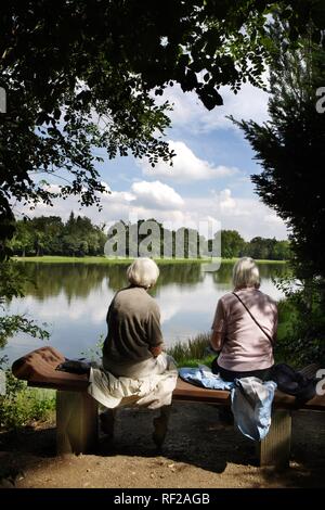 Les touristes assis sur banc avec vue sur un lac à Gartenreich, Dessau-Woerlitz Dessau-Woerlitz Domaine jardin Banque D'Images