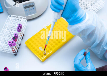Test de l'ADN dans le laboratoire. Distributeur avec le sang et les tubes à essai de près. Une goutte de sang. Banque D'Images