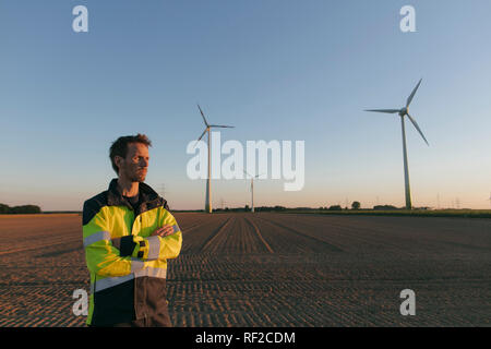 Permanent ingénieur dans un champ à une ferme éolienne Banque D'Images