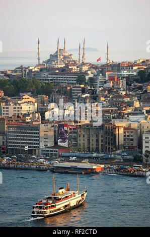Vue sur le quartier de Eminoenue vers une mosquée avec un ferry traversant la corne d'or, Istanbul, Turquie Banque D'Images