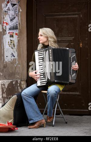 Jeune femme blonde l'accordéon musicien de rue dans le centre historique de Vilnius, capitale de la Lituanie, Pays Baltes Banque D'Images