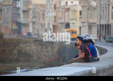 Les jeunes gens assis sur un mur, Malecón, La Havane, Cuba, Caraïbes Banque D'Images