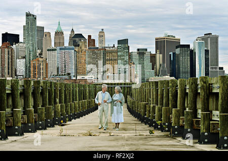 Portrait of happy senior couple walking on alley à ville moderne Banque D'Images