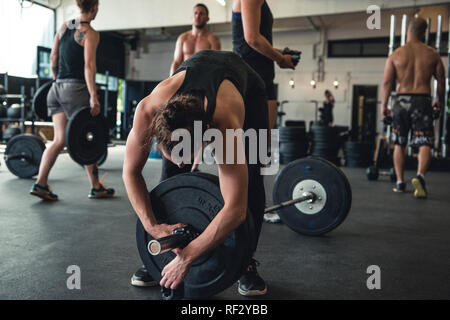 Photos authentiques d'hommes et de femmes travaillant dans une salle de sport. L'équipement de sport utilisé. Banque D'Images