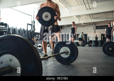 Photos authentiques d'hommes et de femmes travaillant dans une salle de sport. L'équipement de sport utilisé. Banque D'Images