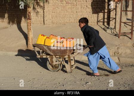 Kandahar, Afghanistan. 22 janvier, 2019. Un garçon Afghan pousse une brouette pour obtenir de l'eau d'une pompe à eau publique de la ville de Kandahar, capitale de la province de Kandahar, au sud de l'Afghanistan, le 22 janvier 2019. Sanaullah Crédit : Seiam/Xinhua/Alamy Live News Banque D'Images