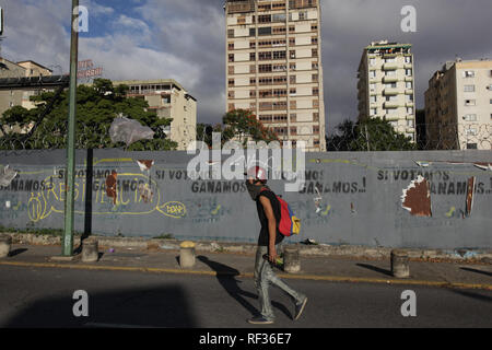 Caracas, Venezuela. 23 Jan, 2019. Au cours d'une manifestation contre le président vénézuélien Maduro, une personne porte une bouteille en verre et un masque. Le président du parlement vénézuélien Guaidó a déclaré le gouvernement socialiste de Maduro d'être privé d'énergie et l'a lui-même proclamé chef de l'État en transition. Quelques minutes plus tard, le président américain Donald Trump, a reconnu le chef de l'opposition comme président intérimaire de la corruption et de pays pauvre. En conséquence, Maduro a ordonné la cessation des relations diplomatiques avec les USA le mercredi. La puissance militaire se tenait derrière Banque D'Images