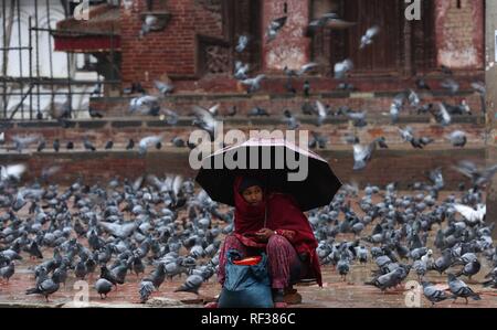 (190124) -- BEIJING, 24 janvier 2019 (Xinhua) -- une femme vend des céréales au cours de la pluie de Hanuman Dhoka à Durbar Square de Katmandou, capitale du Népal, le 23 janvier 2019. (Xinhua/Sunil Sharma) Banque D'Images