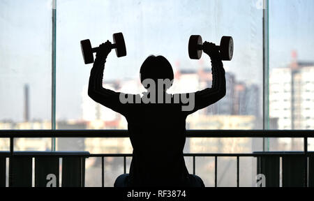 (190124) -- BEIJING, 24 janvier 2019 (Xinhua) -- l'ancien champion national Yu Ping exercices avec haltères courtes à son gymnase à Shanghai, le nord-est de la Chine, la province de Liaoning, le 22 janvier 2019. Yu et son mari, les deux athlètes de lutte, il dirigeait une salle de sport après la retraite. (Xinhua/Yao Jianfeng) Banque D'Images