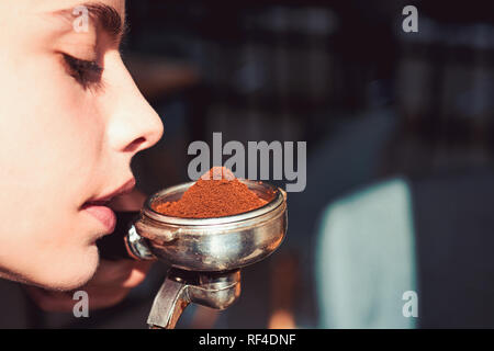 La meilleure odeur dans le monde entier. Femme portafilter barista tenir dans la main. Renifler l'odeur de la femme du café frais. Brew café espresso Barista boire. Dispositif de préparation du café Banque D'Images