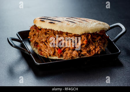 Cuisine latino-américaine vénézuélienne, Arepa avec viande rôtie sur un tableau sombre Banque D'Images