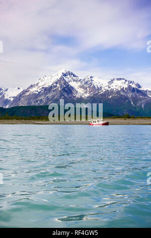 Un bateau à moteur motor cruising yacht ancré dans une belle baie sauvage Cove près de montagnes couvertes de neige, Glacier Bay National Park, Alaska, USA Banque D'Images