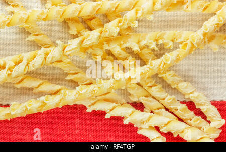 Un groupe de pâtes italiennes appelé busiate sur une nappe de couleur , fils de torsion pâtes sicilienne Banque D'Images