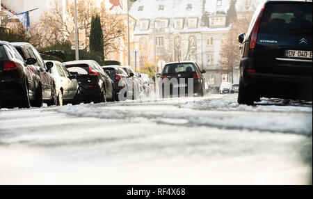 Strasbourg, France - Dec 18, 2018 : avec téléobjectif du Français Rue Daniel Hirtz rue avec des bâtiments haussmanniens et Volkswagen Golf voiture roulant sur la route enneigée Banque D'Images