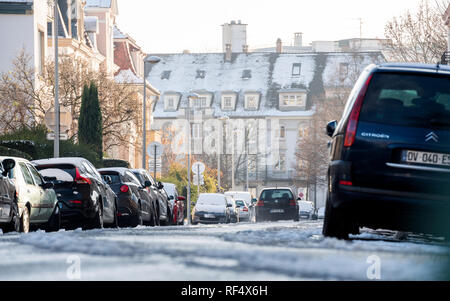 Strasbourg, France - Dec 18, 2018 : avec téléobjectif du Français Rue Daniel Hirtz rue avec des bâtiments haussmanniens et les conducteurs de voitures sur la route enneigée Banque D'Images