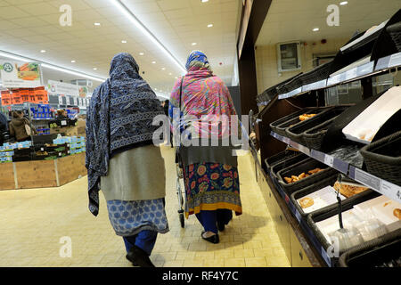 Lidl supermarché shoppers deux personnes âgées vieux femmes portant le foulard foulard ensemble commercial passé marche boulangerie vide étagères en UK KATHY DEWITT Banque D'Images