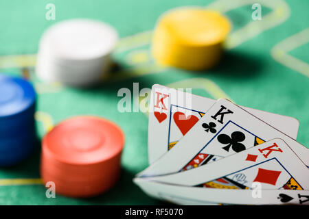 Focus sélectif des cartes à jouer avec des jetons de poker sur table et fond vert Banque D'Images