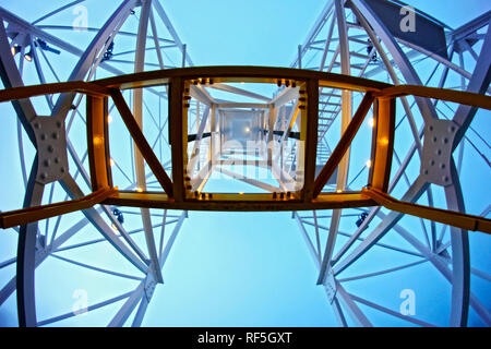 Vue de dessous de la symétrie des supports en métal du carrousel dans un parc d'amusement qui est perdu dans le brouillard. Banque D'Images