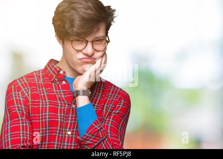 Beau jeune homme portant des lunettes plus de réflexion de fond isolé à fatigué et ennuyé par la dépression Les problèmes avec les bras croisés. Banque D'Images