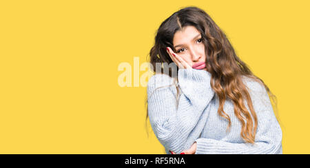 Young Beautiful woman wearing winter sweater pensant à fatigué et ennuyé par la dépression Les problèmes avec les bras croisés. Banque D'Images