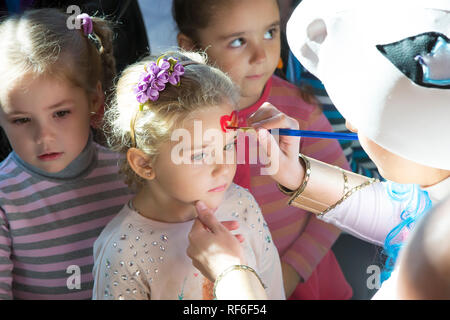 . Fête pour les enfants. L'animateur met un visage peinture sur l'enfant. Banque D'Images