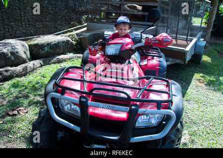 Une photo d'un enfant de 2 ans assis sur un VTT Honda rouge, San Jose, Costa Rica Banque D'Images