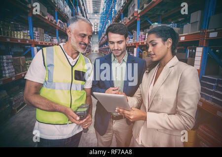 L'équipe d'entrepôt discuter with digital tablet Banque D'Images
