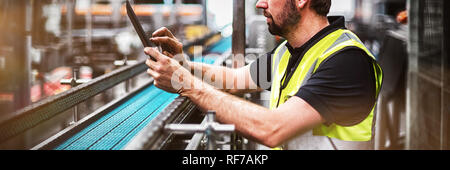 Employé d'usine à l'aide d'une tablette numérique en usine Banque D'Images