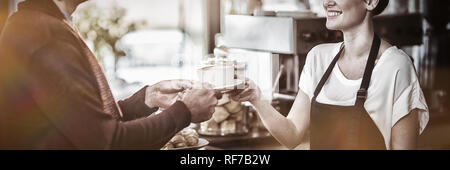 Serveuse de servir une tasse de café au client Banque D'Images