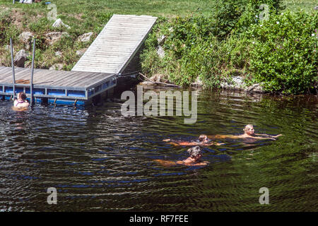Quatre femmes nagent dans l'Otava River, près d'une jetée en bois, du sud de la Bohême, République Tchèque Banque D'Images