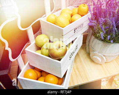 Fruits pommes, oranges et citrons dans des caisses de bois blanc dans le magasin Banque D'Images