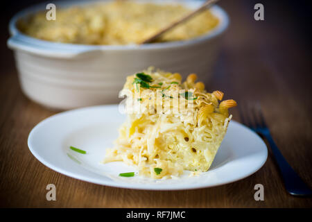 Morceau de cocotte avec des nouilles et des œufs dans une assiette sur une table en bois Banque D'Images