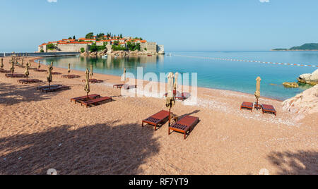 Plage de sable rose Milochre et Sveti Stefan islet matin vue (Monténégro, près de Budva). Les gens méconnaissable. Banque D'Images