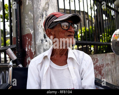 , CAINTA RIZAL, PHILIPPINES - le 17 janvier 2019 : un homme avec un handicap est assis dans son fauteuil roulant et s'intéresse à l'appareil photo. Banque D'Images