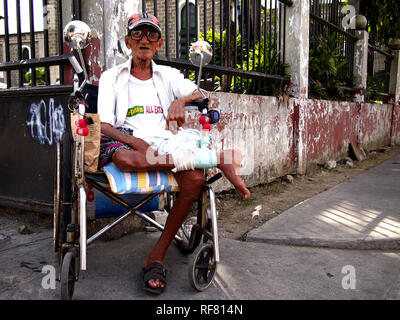 , CAINTA RIZAL, PHILIPPINES - le 17 janvier 2019 : un homme avec un handicap est assis dans son fauteuil roulant et s'intéresse à l'appareil photo. Banque D'Images