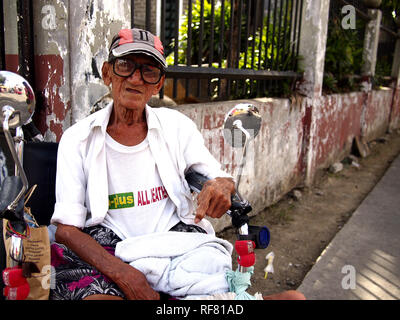 , CAINTA RIZAL, PHILIPPINES - le 17 janvier 2019 : un homme avec un handicap est assis dans son fauteuil roulant et s'intéresse à l'appareil photo. Banque D'Images