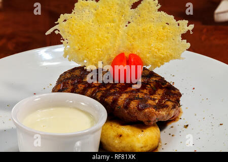 Pavé de boeuf sur l'ensemble de fromage champignons frits et la sauce à l'ail crème de jetons avec des tomates cerises. Close up Banque D'Images