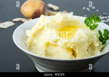 Les pommes de terre biologiques, en purée avec du beurre, du lait, sel de mer et poivre blanc. Le persil sur le dessus. Banque D'Images