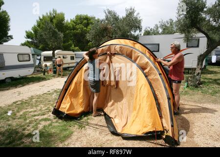 La mise en place d'une tente au camping Kovacine, avec sa plage en béton, natation, et quais, l'île de Cres, Croatie, Europe Banque D'Images