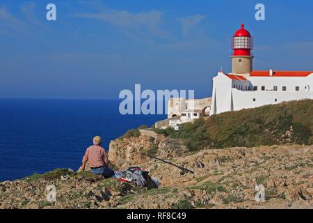 Fisher en face du phare de Cabo de Sao Vicente, Algarve, Portugal Banque D'Images