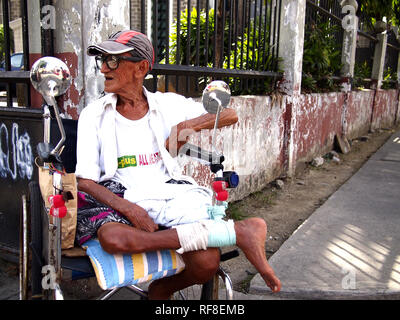 , CAINTA RIZAL, PHILIPPINES - le 17 janvier 2019 : un homme avec un handicap est assis dans son fauteuil roulant et s'intéresse à l'appareil photo. Banque D'Images