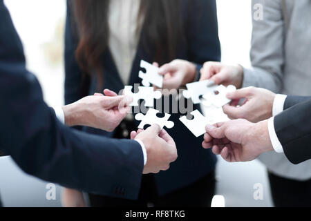 Groupe de gens d'affaires d'assembler un puzzle, l'appui de l'équipe Banque D'Images