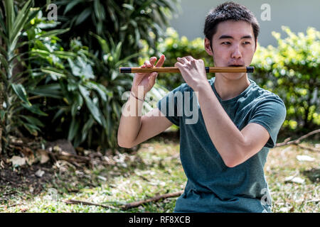 Un homme japonais jouant et vieille flûte dans un bel environnement naturel Banque D'Images