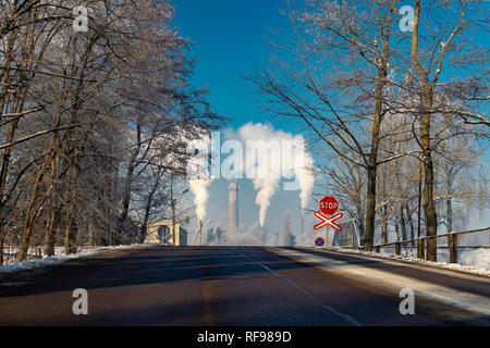 Vue vers le bas d'une rue d'hiver du tabagisme des cheminées dans un district industriel dans un concept de la pollution de l'atmosphère Banque D'Images