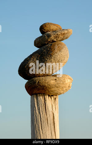 Rock Balancing, équilibrage de la pierre, de la pierre ou de la pile Pile Rock Art de la terre sur le bois de la Camargue Provence France Banque D'Images