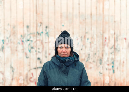 Portrait de femme coincée en difficulté dans la rue par une froide journée d'hiver looking at camera Banque D'Images