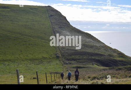 Un groupe de trois randonneurs sur le sentier de St Alban's Head sur le chemin côtier du sud-ouest dans le Dorset, Angleterre, Royaume-Uni. Banque D'Images