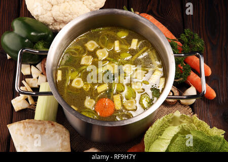 Bouillon avec carottes, oignons divers légumes frais dans un pot - frais colorés clear spring soupe. Cuisine végétarienne paysage rural bouillon Banque D'Images