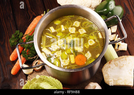 Bouillon avec carottes, oignons divers légumes frais dans un pot - frais colorés clear spring soupe. Cuisine végétarienne paysage rural bouillon Banque D'Images